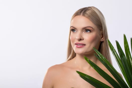 A captivating beauty portrait of a model gracefully posing with a plant, showcasing natural elegance