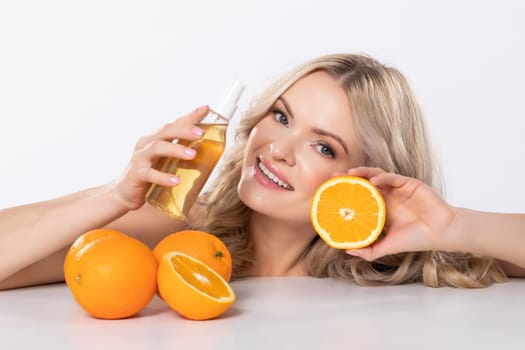 A cheerful woman is enjoying fresh oranges and delicious juice while celebrating the joy of healthy living