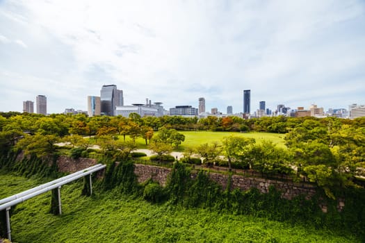 OSAKA, JAPAN - SEPTEMBER 25 2024: The iconic Osaka Castle and surrounding moat and gardens on a warm clear autumn day in Osaka, Japan on September 25th 2024