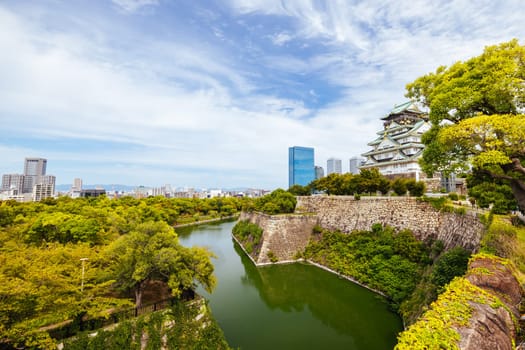 OSAKA, JAPAN - SEPTEMBER 25 2024: The iconic Osaka Castle and surrounding moat and gardens on a warm clear autumn day in Osaka, Japan on September 25th 2024