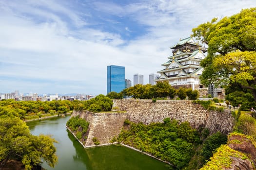 OSAKA, JAPAN - SEPTEMBER 25 2024: The iconic Osaka Castle and surrounding moat and gardens on a warm clear autumn day in Osaka, Japan on September 25th 2024