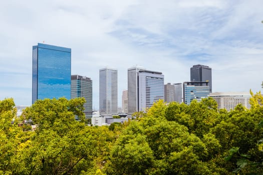 OSAKA, JAPAN - SEPTEMBER 25 2024: Views towards the Shiromi business district and Osaka-Jo Hall from Osaka Castle on a warm autumn day in Osaka, Japan on September 25th 2024