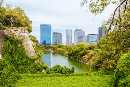 OSAKA, JAPAN - SEPTEMBER 25 2024: The iconic Osaka Castle and surrounding moat and gardens on a warm clear autumn day in Osaka, Japan on September 25th 2024