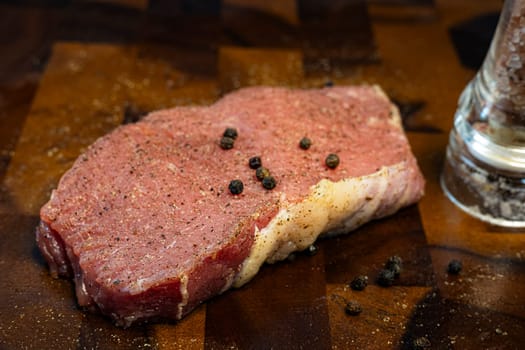 Raw beef meat to make juicy steak with spices and herbs. Raw beef fillet piece on wooden board. 