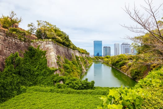 OSAKA, JAPAN - SEPTEMBER 25 2024: The iconic Osaka Castle and surrounding moat and gardens on a warm clear autumn day in Osaka, Japan on September 25th 2024