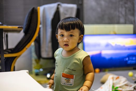 Little boy in messy bedroom.