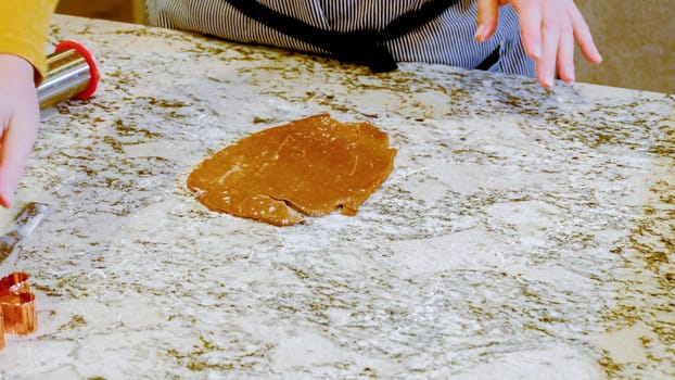 Using an adjustable rolling pin to roll out gingerbread cookie dough on the elegant marble counter in a modern kitchen, getting ready for festive holiday baking.