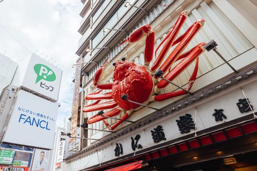 OSAKA, JAPAN - SEPTEMBER 24 2024: Osaka's famous Dotonbori area with many restaurants and iconic food signage, including moving lobsters in Osaka, Japan