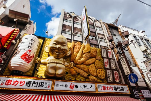 OSAKA, JAPAN - SEPTEMBER 24 2024: Osaka's famous Dotonbori area with many restaurants and iconic food signage, including this golden baby in Osaka, Japan