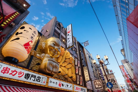 OSAKA, JAPAN - SEPTEMBER 24 2024: Osaka's famous Dotonbori area with many restaurants and iconic food signage, including this golden baby in Osaka, Japan
