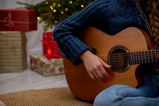 A beautiful and festive scene showcasing a person happily playing their guitar near colorful Christmas decorations