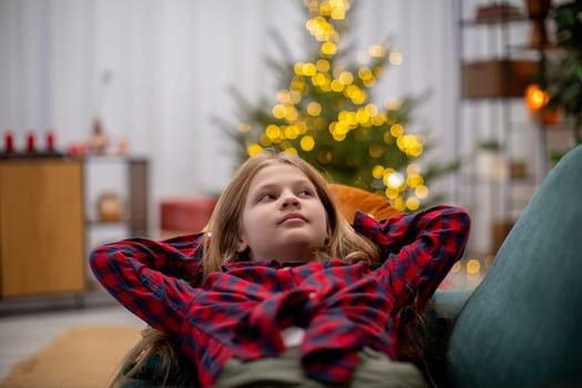 A joyful child relaxes in a cozy, warm setting, surrounded by festive decorations and glowing lights