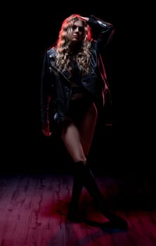 A truly striking fashion pose that vividly showcases an edgy and bold style against a dark backdrop environment