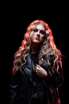 A striking portrait featuring a model with curly hair wearing a leather jacket against a dramatic backdrop.