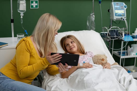 In a hospital setting, a comforting moment occurs between a loving mother and her sick child, providing care