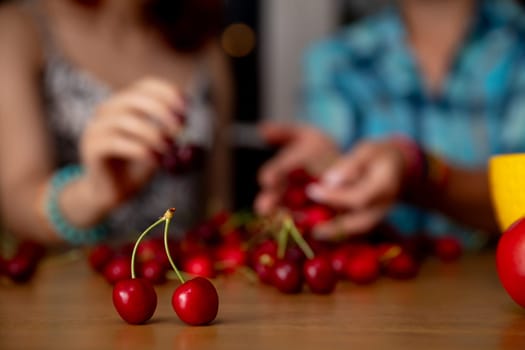 Two close friends are joyfully enjoying some cherry picking together in a relaxed, delightful environment