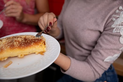 A closeup of a creamy dessert being sliced, showcasing its golden crust and inviting, luscious texture