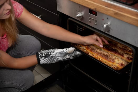 A skilled individual gently takes a freshly baked pizza out of the oven, demonstrating their impressive culinary skills