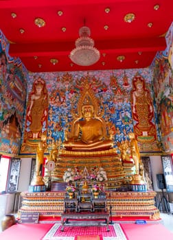The peaceful interior has a majestic Buddha statue and colorful murals in a calming temple atmosphere