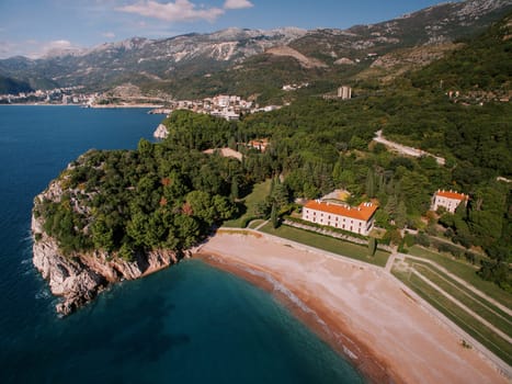Royal beach near Villa Milocer at the foot of the green mountains. Montenegro. Drone. High quality photo