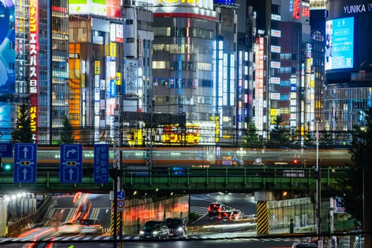 TOKYO, JAPAN, SEPTEMBER 16 2024: Train and traffic in Tokyo’s busy Shinjuku neighborhood at night in Japan