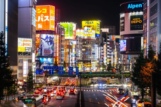TOKYO, JAPAN, SEPTEMBER 16 2024: Train and traffic in Tokyo’s busy Shinjuku neighborhood at night in Japan