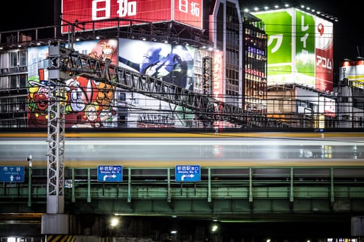TOKYO, JAPAN, SEPTEMBER 16 2024: Train and traffic in Tokyo’s busy Shinjuku neighborhood at night in Japan