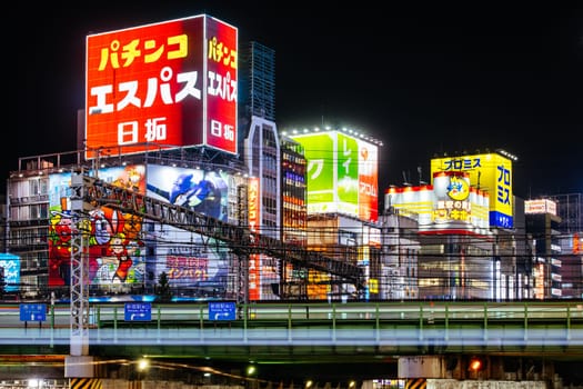TOKYO, JAPAN, SEPTEMBER 16 2024: Train and traffic in Tokyo’s busy Shinjuku neighborhood at night in Japan