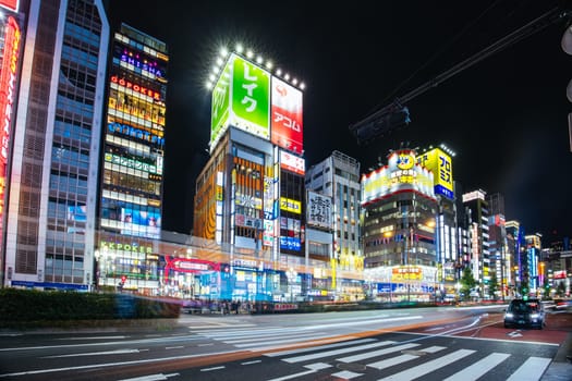 TOKYO, JAPAN, SEPTEMBER 16 2024: Neon signs illuminate with traffic in Tokyo’s busy Shinjuku neighborhood at night in Japan
