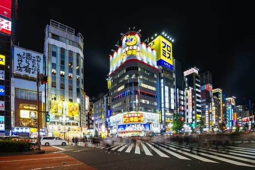 TOKYO, JAPAN, SEPTEMBER 16 2024: Neon signs illuminate with traffic in Tokyo’s busy Shinjuku neighborhood at night in Japan