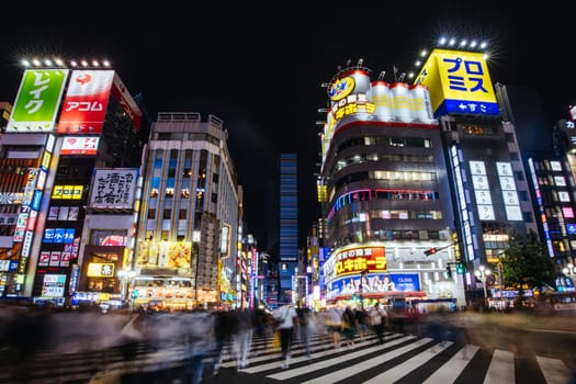 TOKYO, JAPAN, SEPTEMBER 16 2024: Neon signs illuminate with traffic in Tokyo’s busy Shinjuku neighborhood at night in Japan
