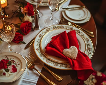 Festive table setting with candles and arrangement of beautiful red flowers. Holiday concept. High quality photo