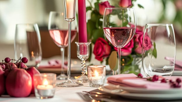Festive table setting with candles and arrangement of beautiful red flowers. Holiday concept. High quality photo