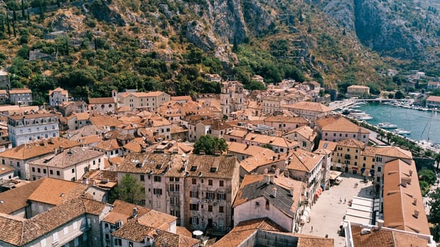 Narrow streets and small squares with old stone houses with red roofs. Kotor, Montenegro. Drone. High quality photo