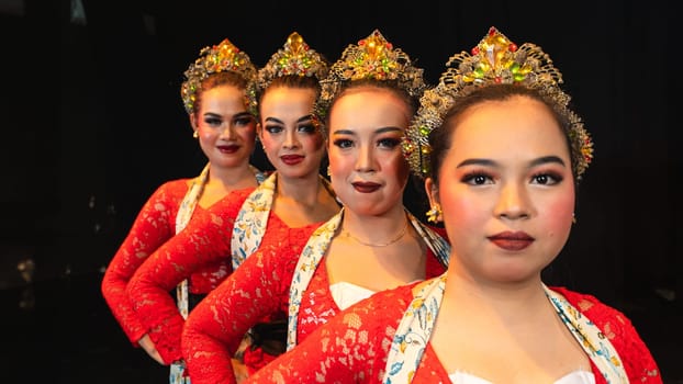a group of Javanese dancers wearing uniform red costumes creates visual harmony that amazes the audience at night