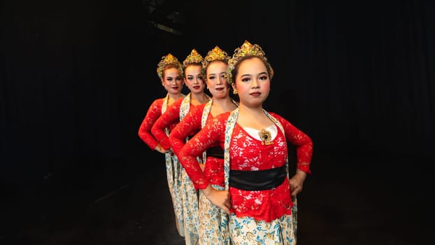 a group of Javanese dancers wearing uniform red costumes creates visual harmony that amazes the audience at night