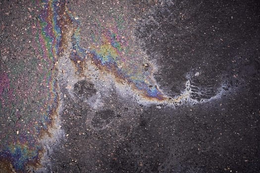 Gasoline or oil spill on asphalt creating rainbow color pattern