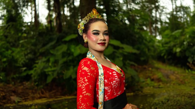 a traditional dancer called ronggeng stands with an expression full of beauty and beauty in a magical forest in the afternoon
