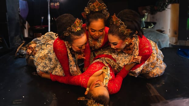 a group of traditional Javanese dancers wearing red costumes which provide a dramatic effect on the stage at night