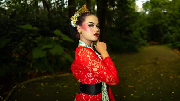 a traditional dancer called ronggeng stands with an expression full of beauty and beauty in a magical forest in the afternoon