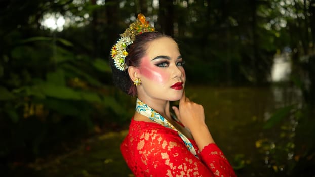 a traditional dancer called ronggeng stands with an expression full of beauty and beauty in a magical forest in the afternoon