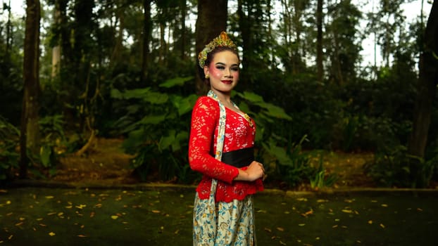 a traditional dancer called ronggeng stands with an expression full of beauty and beauty in a magical forest in the afternoon