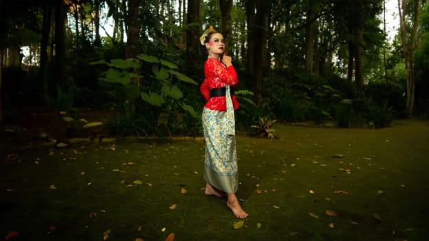 a traditional dancer called ronggeng stands with an expression full of beauty and beauty in a magical forest in the afternoon