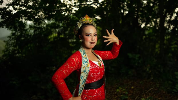 a traditional Indonesian dancer performs in a traditional ceremony and cultural festival in the forest in the morning