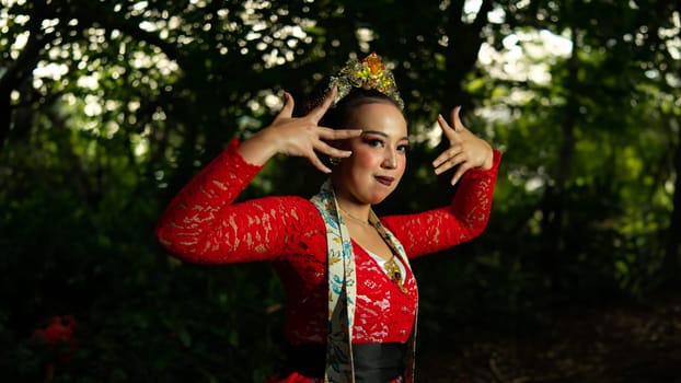 a traditional Indonesian dancer performs in a traditional ceremony and cultural festival in the forest in the morning