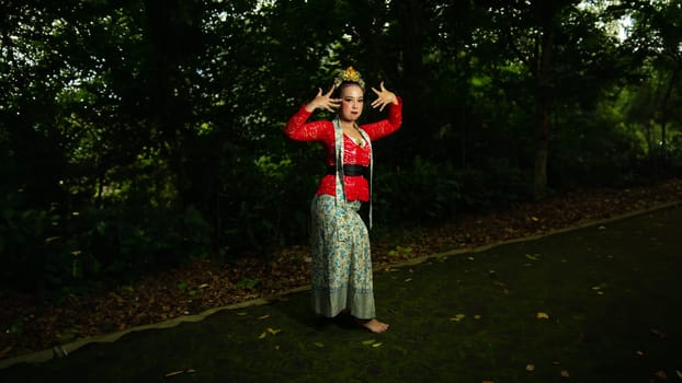 a traditional Indonesian dancer performs in a traditional ceremony and cultural festival in the forest in the morning