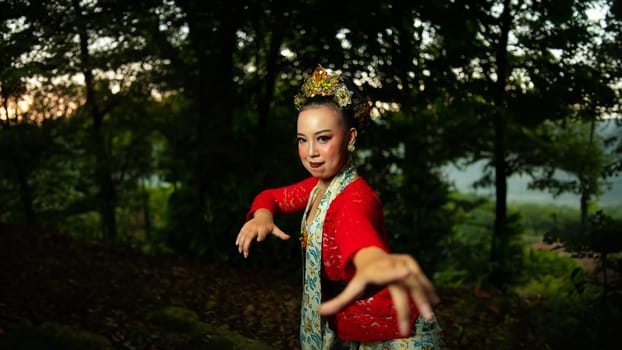 a traditional Balinese dancer wearing a red costume which is a symbol of cultural preservation with beautiful motifs while in the forest in the morning