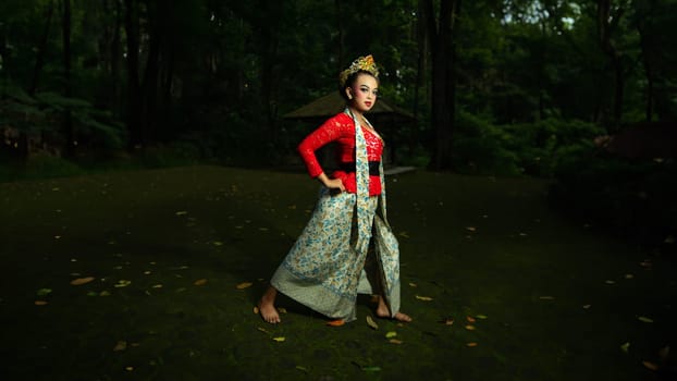 A traditional Javanese dancer wears jewelry on a red costume such as bracelets and necklaces to add to the impression of luxury when dancing in the forest in the morning