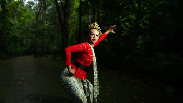 Indonesian traditional dancers wear red costumes with gold crown decorations which are very majestic when in the forest in the morning