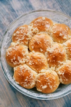 Glass dish with ruddy donuts sprinkled with grated garlic on the table. High quality photo